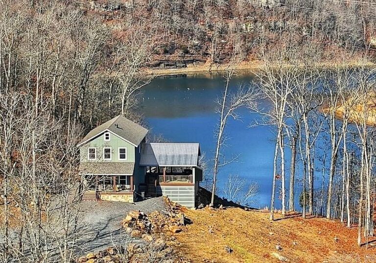 Pretty porch and setting! Over 7 acres in Arkansas. $989,000.