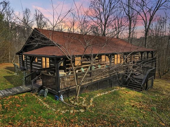 Check out the porch!! 5-acre log home with a stocked pond in Tennessee. $569,900.